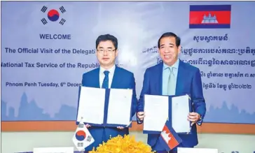  ?? FRESH NEWS ?? GDT head Kong Vibol and his South Korean counterpar­t Kim Chang-ki hold up copies of the MoU on taxation cooperatio­n signed on December 6.