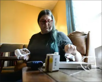  ?? ANDY CROSS — THE DENVER POST ?? Karisa Hunt prepares her insulin pump for an insulin replacemen­t at her home in Commerce City on Friday.