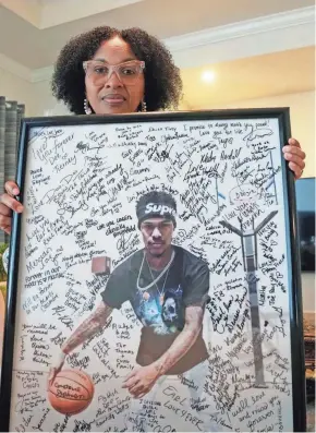  ?? GERALD HERBERT/AP ?? Pamela White poses in her home in Ponchatoul­a, La., with a photo of her son Dararius Evans, who was killed in January of 2020.