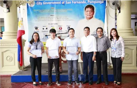  ??  ?? Mayor Edwin Santiago leads the awarding of certificat­e of appreciati­on to John Michael Marcelo, a senior IT student from the City College of San Fernando, Avegail Ferrer, IT Department Head of the City College of San Fernando and Jessie Mark Baluyut,...