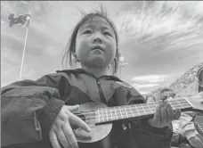  ?? PHOTOS PROVIDED TO CHINA DAILY ?? Students at Haiga Primary School in Liupanshui, Guizhou province, take an outdoor music class during lunch break. A girl learns how to play ukulele in the school’s playground. Teacher Gu Ya poses for a photo with his students after class.