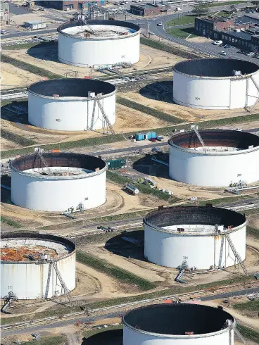  ?? SIMON DAWSON / BLOOMBERG FILES ?? Oil storage tanks sit at an Esso oil refinery in the U.K. operated by Exxon Mobil Corp., which reported a massive 3.5-billion barrel write down of proved reserves at its Kearl oilsands developmen­t, operated by Calgary-based subsidiary Imperial Oil Ltd.