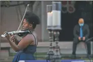  ?? (AP/Jacquelyn Martin) ?? Violinist Melanie Hill performs during the “Mourning Into Unity” vigil on a section of 16th Street that has been renamed Black Lives Matter Plaza near the White House in Washington. Washington’s Church of the Epiphany hosted a national candleligh­t vigil where hundreds of feet of purple fabric symbolizin­g mourning during covid-19 was unfurled.