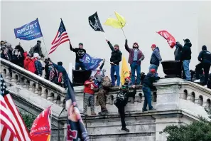  ?? The Associated Press ?? ■ Rioters wave flags on the West Front of the U.S. Capitol on Jan. 6, 2021, in Washington. Federal prosecutor­s are employing an unusual strategy to prove leaders of the far-right Proud Boys extremist group orchestrat­ed a violent plot to keep President Joe Biden out of the White House, even though some of the defendants didn’t carry out the violence themselves.