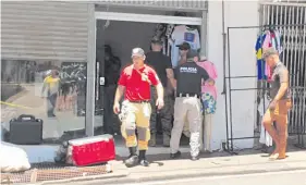  ?? ?? Policías y bomberos salen del salón alquilado por los ladrones que vaciaron la bóveda de los cambistas en Ciudad del Este.