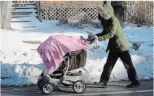  ?? CATHIE COWARD THE HAMILTON SPECTATOR ?? A woman is forced into the street due to uncleared sidewalk snow.