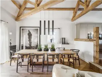  ??  ?? Kitchen A trio of ‘Caravaggio’ pendant lights by Cecilie Manz for Fritz Hansen hangs above the island in this contempora­ry, neutral space.
The cabinets have been repainted to match the scheme and the counter stools are the ‘Beetle’ by GamFratesi for Gubi. Two metal shelving units from Garden Trading add extra storage space Dining room Perfect for entertaini­ng, the 10-seater table designed by Kelly is surrounded by Hans J Wegner’s ‘Wishbone’ chairs for Carl Hansen & Søn. The ‘Pixo’ lights above are by Formalight­ing and the photograph is Sissinghur­st by Richard Dunkley