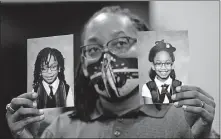  ??  ?? In this Oct. 27 photo, Sheldon Smith holds the photograph­s of his children Deshawn Smith, 11, left, and Trinitee Smith, 13, both suffering from sickle cell anemia, during an Initiative 65 rally in Ridgeland, Miss. Smith and his wife Keishawna Smith believe their children would benefit from medical marijuana treatment for pain management. Initiative 65 would amend the Mississipp­i Constituti­on to allow the prescripti­on by a doctor of up to 5 ounces (142 grams) of marijuana per month for people who suffer from more than 20 medical conditions. [ROGELIO V. SOLIS/ASSOCIATED PRESS FILE PHOTO]