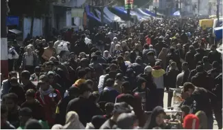  ?? ?? Des Palestinie­ns envahissen­t un marché à Rafah, dans la bande de Gaza, jeudi 22 février 2024.