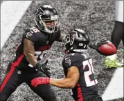  ??  ?? Falcons wide receiver Calvin Ridley (left) celebrates a 4-yard touchdown catch with running back Ito Smith during the second quarter at Mercedes-benz Stadium.