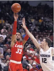  ?? ISAAC BREKKEN /ASSOCIATED PRESS ?? New Mexico’s Anthony Mathis, left, takes aim the basket during the Lobos’ MWC quarterfin­al game against Utah State on Thursday night. He had 14 points and was 4-for-13 shooting from the field.