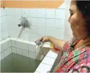  ?? UMAR WIRAHADI/JAWA POS ?? BELUM NORMAL: Eni, warga Jalan Proklamasi, Kelurahan Sidokumpul, memutar keran air di kamar mandinya kemarin.