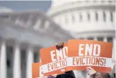  ?? ?? Activists hold “end evictions” signs Sept. 21 on Capitol Hill in Washington.