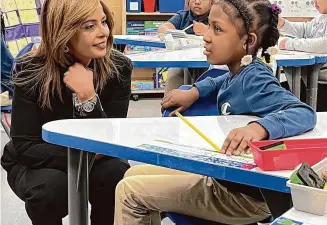  ?? Mark Zaretsky/Hearst Connecticu­t Media ?? New Haven's new Superinten­dent of Schools Madeline Negrón speaks to a second grade student in teacher Mercedes Ellis' class at Lincoln-Bassett Community School in the Newhallvil­le section the morning after her contract was approved in April.