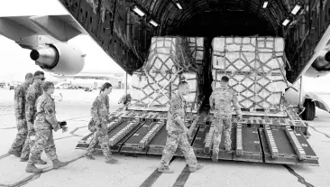  ?? AP ?? Crew members of a C-17 begin to unload baby formula at the Indianapol­is Internatio­nal Airport on Sunday. The 132 pallets of Nestlé Health Science Alfamino Infant and Alfamino Junior formula arrived from Ramstein Air Base in Germany.