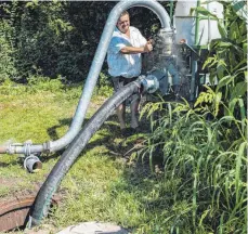  ?? FOTO: MARK HILDEBRAND­T ?? Hubert Bernhard pumpt Wasser aus einem bodenseena­hen Brunnen in eine Bewässerun­gsanlage. Mobile Anlagen wie diese kommen in der ganzen Region zum Einsatz.