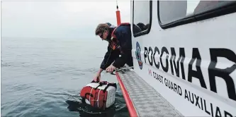  ?? DAVE JOHNSON THE WELLAND TRIBUNE ?? Port Colborne Marine Auxiliary Rescue (POCOMAR) unit’s operations officer Scott Wolfe checks on a plastic drum, representi­ng a person who had in been the water for at least an hour, during a large-scale search and rescue training exercise.