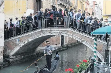  ?? PHOTO: GETTY IMAGES ?? Packed . . . Tourists crowd a bridge in Venice, Italy.