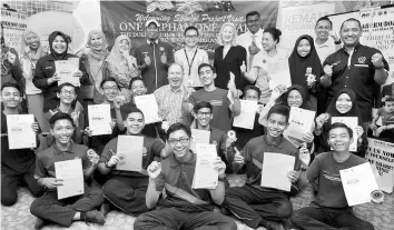  ??  ?? John May (centre) in a group photo with recipients of ‘Remaja Muda Perdana Rakan Muda’ award. — Bernama photo