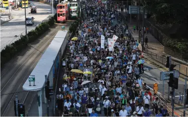  ?? (Tyrone Siu/Reuters) ?? DEMONSTRAT­ORS MARCH yesterday in Hong Kong to protest against the jailing of student leaders Joshua Wong, Nathan Law and Alex Chow.