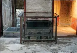  ?? ?? The remains of one of two bronze safes are seen Dec. 14 in the atrium of the House of Vettii.