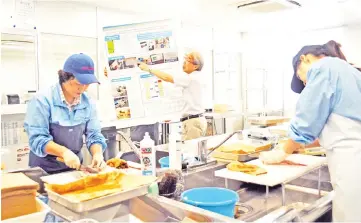  ??  ?? Onahama Port employees preparing seafood for radiation tests in Iwaki.