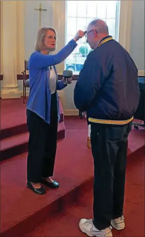  ?? TAWANA ROBERTS ?? The Rev. Beverly Wrobel, associate pastor of Mentor United Methodist Church, applies ashes to member Kurt Hinkley’s forehead on March 1. Ash Wednesday marks the beginning of the Lenten season.