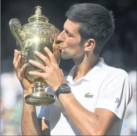  ?? NEIL HALL — THE ASSOCIATED PRESS ?? Novak Djokovic kisses the Wimbledon men’s singles trophy after defeating a weary Kevin Anderson in straight sets, 6-2, 6-2, 7-6 (3), Sunday in London. It’s his 13th major title.
