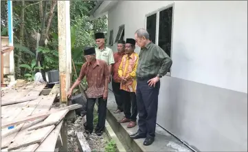 ??  ?? Wan Junaidi (right) looks at Mohd Yusuf’s old house made of wood and in poor condition.