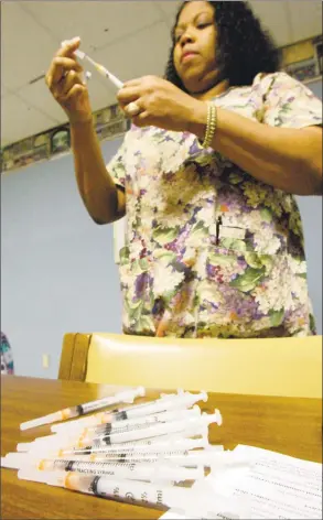  ?? Danny Johnston / Associated Press file photo ?? Registered nurse Nicy Tennessee prepares flu vaccines in November 2005, at Central Arkansas Veterans Healthcare System in Little Rock, Ark. The Veteran’s System is offering free flu vaccines to veterans who are enrolled for care.