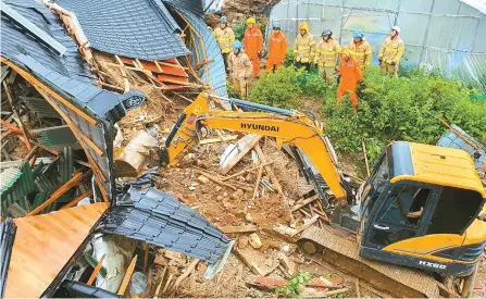  ?? Yonhap ?? Firefighte­rs carry out a search operation at a chicken farm collapsed by a landslide in Anseong, Gyeonggi Province, Sunday.