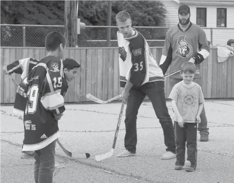  ?? GREG PENDER/The StarPhoeni­x ?? Darcy Kuemper of the Minnesota Wild, Eric Gryba of the Ottawa Senators and James Wright of Winnipeg Jets play a floor hockey game with the King
George school’s Kinsmen Hockey League team on Thursday.