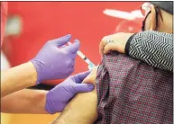  ?? Ned Gerard / Hearst Connecticu­t Media ?? A nurse delivers a shot of COVID-19 vaccine into the arm of a patient during a clinic set up in the gymnasium of Central High School in Bridgeport on Jan. 20.