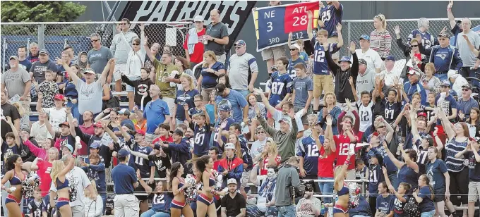  ?? STAFF PHOTO BY JOHN WILCOX ?? SIGNS OF EXCITEMENT: Patriots fans fill the stands alongside the Gillette Stadium practice field yesterday for opening day of training camp.