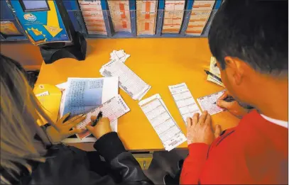  ?? Richard Brian ?? Las Vegas Review-journal @vegasphoto­graph Customers make their lottery picks Friday at The Lotto Store on the California side of Primm.