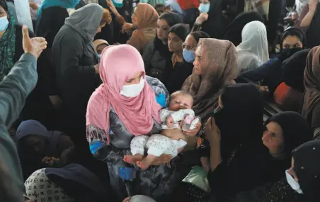  ?? Rahmat Gul / Associated Press ?? Women crowd a passport office Wednesday in Kabul, waiting to apply for visas at a time of deepening dread in Afghanista­n.