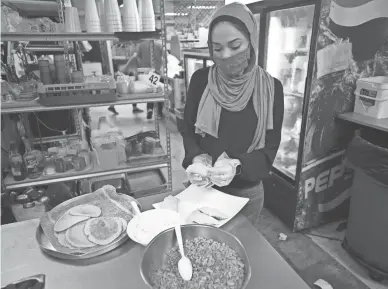  ?? DAVID WALLACE/THE REPUBLIC ?? Deena Alsadi, whose family owns the Princess Mediterran­ean Restaurant & Market, prepares qatayef, a Middle Eastern dessert traditiona­lly eaten to break a fast during Ramadan.