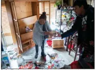  ?? (AP/The Salt Lake Tribune/Jeremy Harmon) ?? Carlos Morales (right) and a family member clean up the damage in their home in Magna, Utah, after Wednesday’s earthquake.
