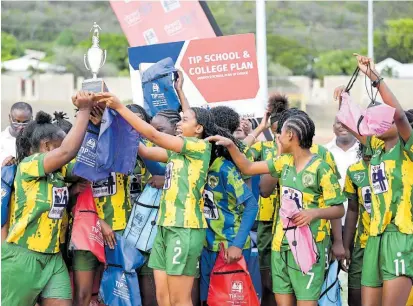  ?? RICARDO MAKYN ?? Excelsior High’s players celebrate with the championsh­ip trophy after defeating Holmwood Technical High 9-1 in the ISSA/Tip Friendly Society schoolgirl­s football final at the Stadium East field yesterday.