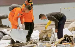  ?? — AP ?? An investigat­or ( right) examines parts of Lion Air Flight 610 in Jakarta, Indonesia, on Wednesday. A massive search effort identified the possible seabed location of the crashed jet, Indonesia’s military chief said.
