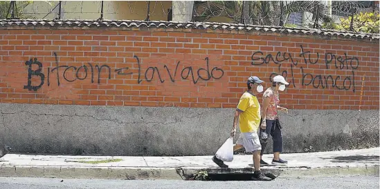 ??  ?? Rechazo. Una pinta en un muro de una colonia en El Salvador evidencia que la población rechaza el uso obligatori­o del bitcóin como moneda legal.