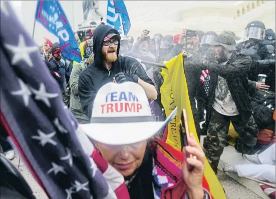  ?? JOHN MINCHILLO / AP ?? Partidario­s de Donald Trump se enfrentan a las fuerzas del orden dentro del Capitolio durante el asalto del pasado 6 de enero