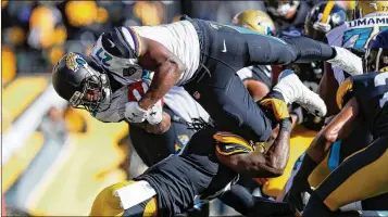  ?? KEVIN C. COX / GETTY IMAGES ?? Jaguars running back Leonard Fournette dives into the end zone in the first quarter for the first of his three TDs in Sunday’s victory. He ran for 109 yards on 25 carries and caught two passes for 10 yards.