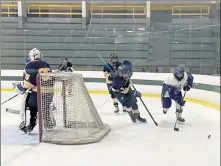  ?? NICK MALLARD / SENTINEL & ENTERPRISE ?? Lunenburg/Ayer Shirley’s Nathan Handy controls the puck as Littleton/ Bromfield’s Aaron King defends behind goaltender Aiden LeDuc.