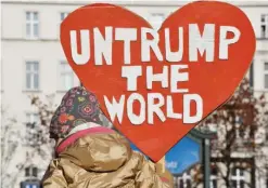  ?? BERLIN: A demonstrat­or protesting against US President-Elect Donald Trump displays a heart-shaped placard during a demonstrat­ion yesterday. ?? — AFP