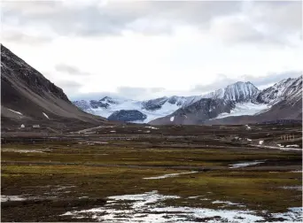  ??  ?? IS IT GETTING warmer? Snow covers Broggerdal­en Mountain near Ny-Alesund, Norway, in 2015. The author discusses the case of columnist Bret Stephens, who was attacked for taking issue with climate change.