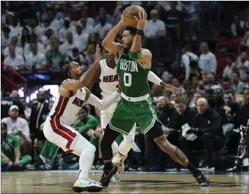  ?? PHOTOS BY LYNNE SLADKY – THE ASSOCIATED PRESS ?? The Celtics' Jayson Tatum looks to pass while pressured by Heat defenders Gabe Vincent, left, and Victor Oladipo.