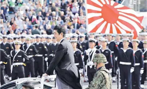  ??  ?? ► Shinzo Abe pasa revista a las fuerzas de autodefens­a japonesas en la base Asaka, en octubre de 2016.