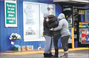  ?? KARL MONDON — STAFF PHOTOGRAPH­ER ?? People grieve outside Hillside Market in unincorpor­ated Daly City on Monday in the wake of a double homicide that occurred there Sunday night.