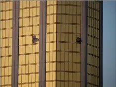  ??  ?? Drapes billow out of broken windows at the Mandalay Bay resort and casino Monday, on the Las Vegas Strip following a deadly shooting at a music festival in Las Vegas. A gunman was found dead inside a hotel room.